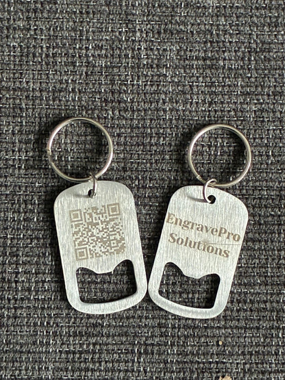 Two metal bottle opener keychains on a textured gray background
