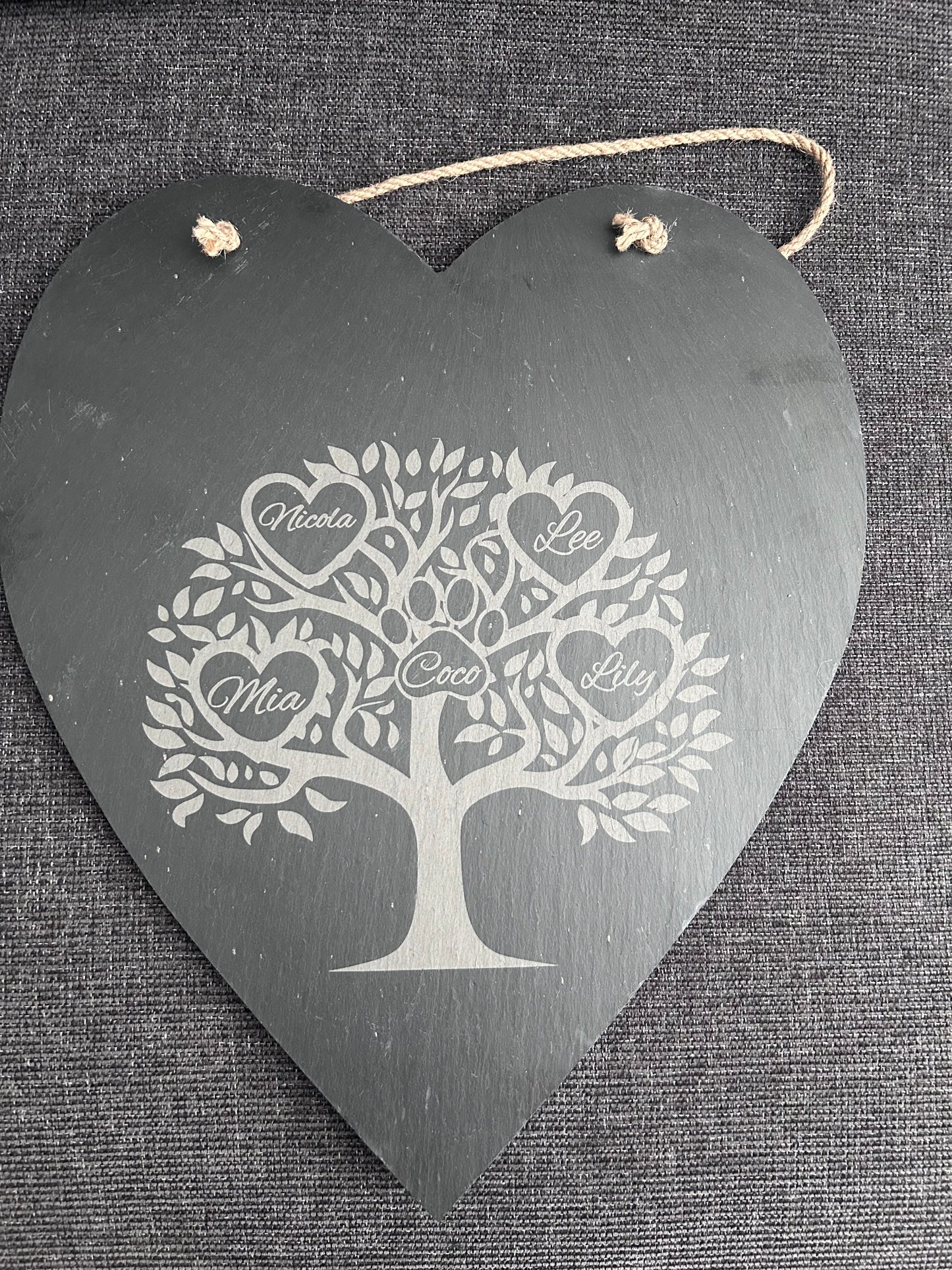 Decorative slate hanging plaque with family tree design on a textured  background with hearts for names and a paw print for pet names