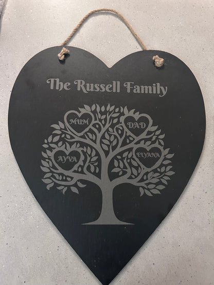 Heart-shaped family tree plaque with engraved names hanging on a wall 