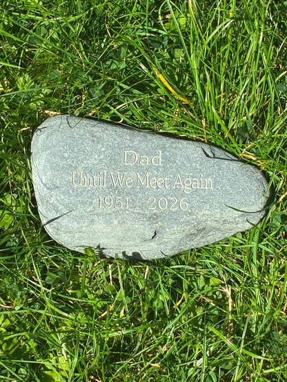 Natural grey memorial stone engraved with a personalised remembrance message for Dad, displayed on grass