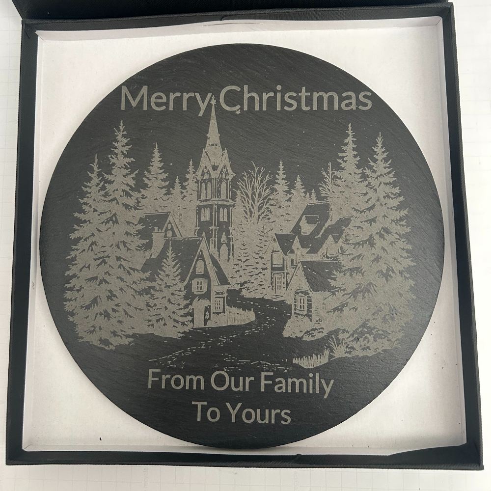 Round slate serving board engraved with Christmas village design and festive message