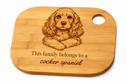 Wooden cutting board with a engraved cocker spaniel and text on a white background