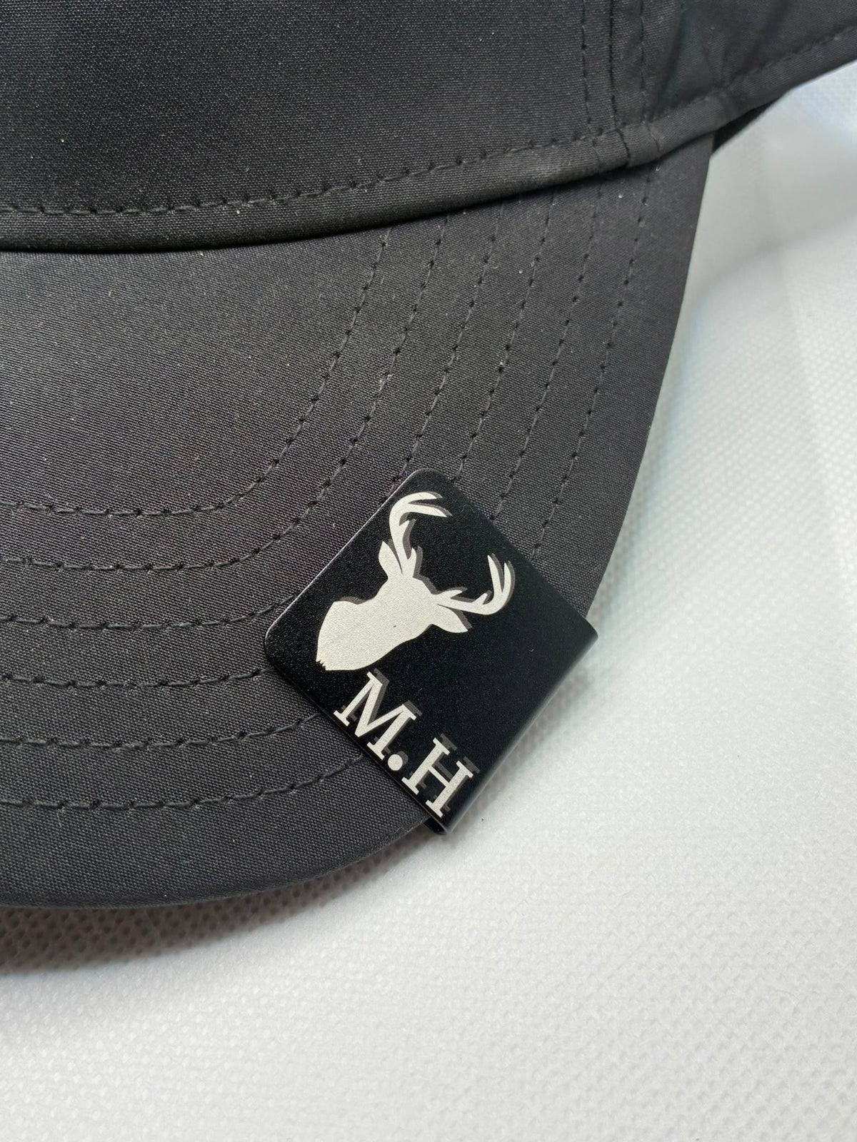 Personalised engraved metal cap clip fitted to a pink cap