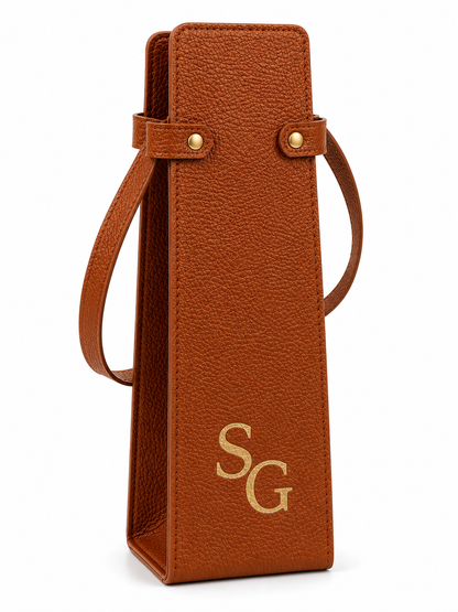 Personalised brown faux leather wine bottle carrier with laser engraved initials on a white background.